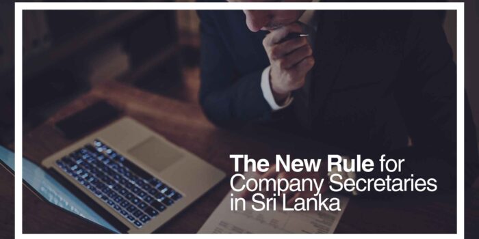Strengthening Corporate Governance: New Rules for Company Secretaries A professional person in a suit seated at a desk, focusing on company documents and a laptop, symbolizing corporate governance and adherence to regulations in Sri Lanka. The text emphasizes "The New Rule for Company Secretaries in Sri Lanka