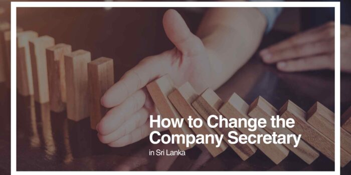 How to Change the Company Secretary in Sri Lanka: A Visual Guide A hand stopping a row of wooden dominoes from falling, symbolizing intervention or change in corporate processes.